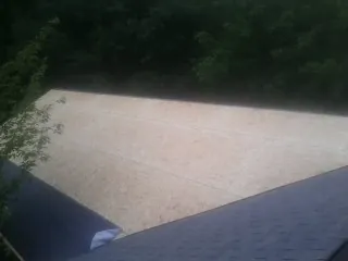 New OSB roof sheathing installed beside an existing shingle roof in Hurt