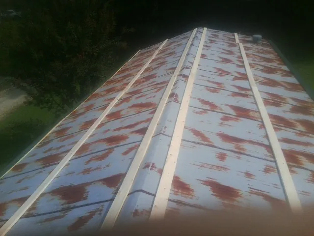 Rusted metal roof panels with new wood purlins before replacement — Storm Damage Roof Repair in Hurt by Roofing Brothers