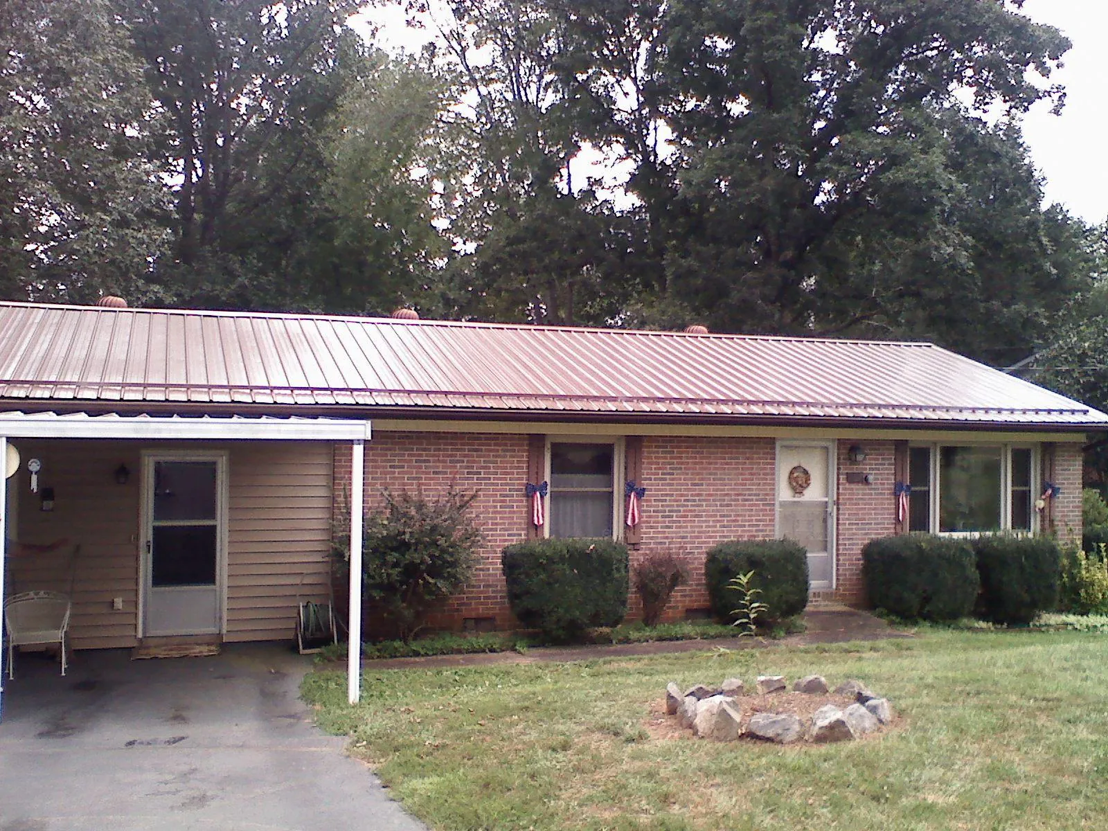 Bronze metal roof and carport on a brick ranch home — Roof Repair work by our crew in Hurt
