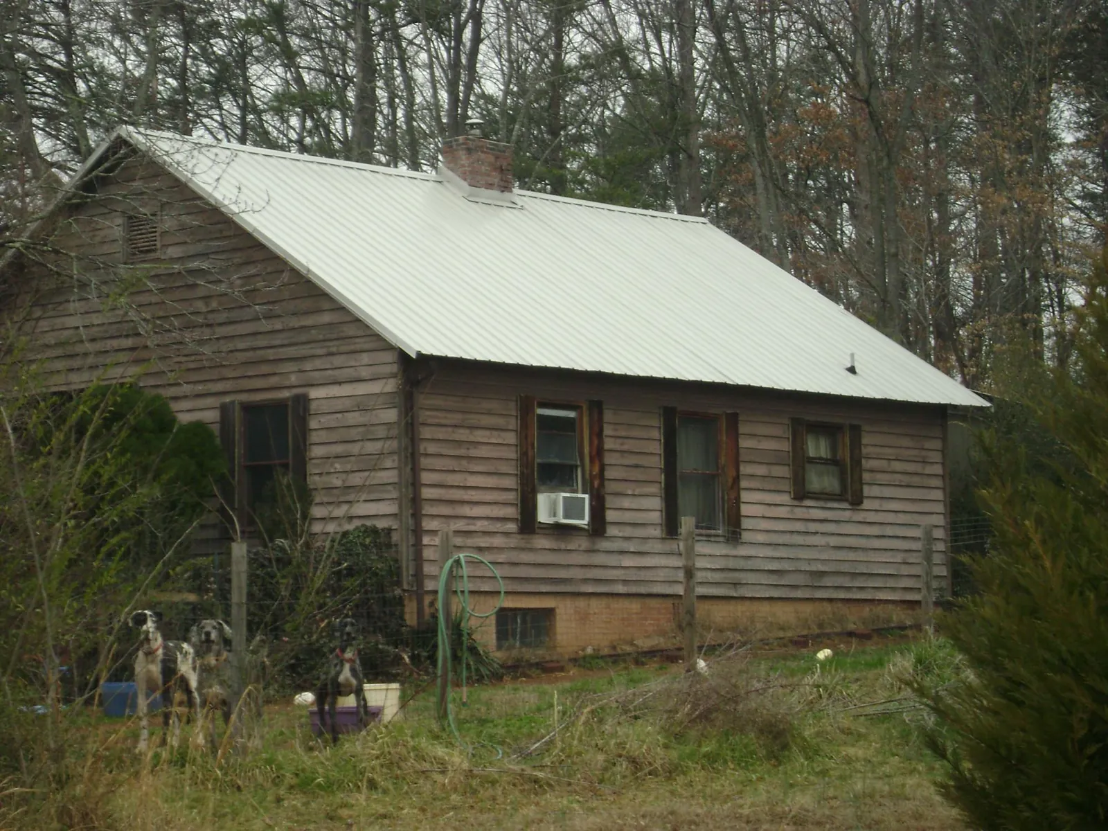 White metal roof on an old wood sided farmhouse, from a Metal Roof Installation job in Hurt